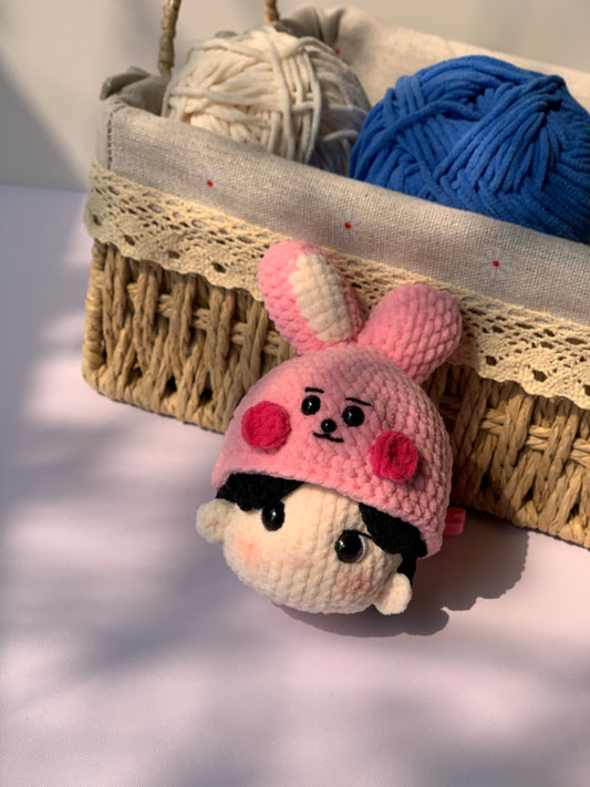 BTS JungKook Amigurumi keychain in front of a basket of yarn.