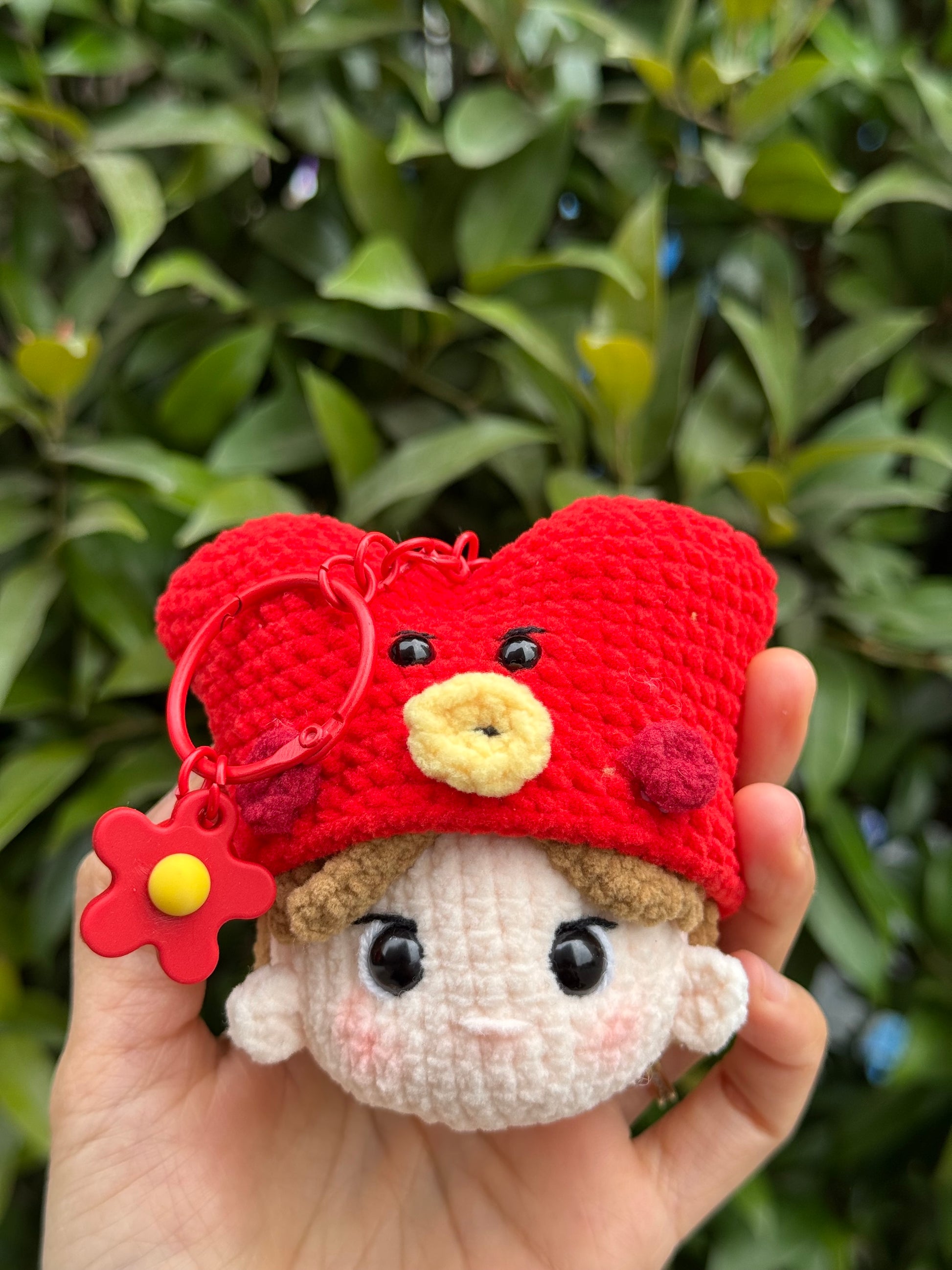 Hand holding a BTS V amigurumi with a keychain